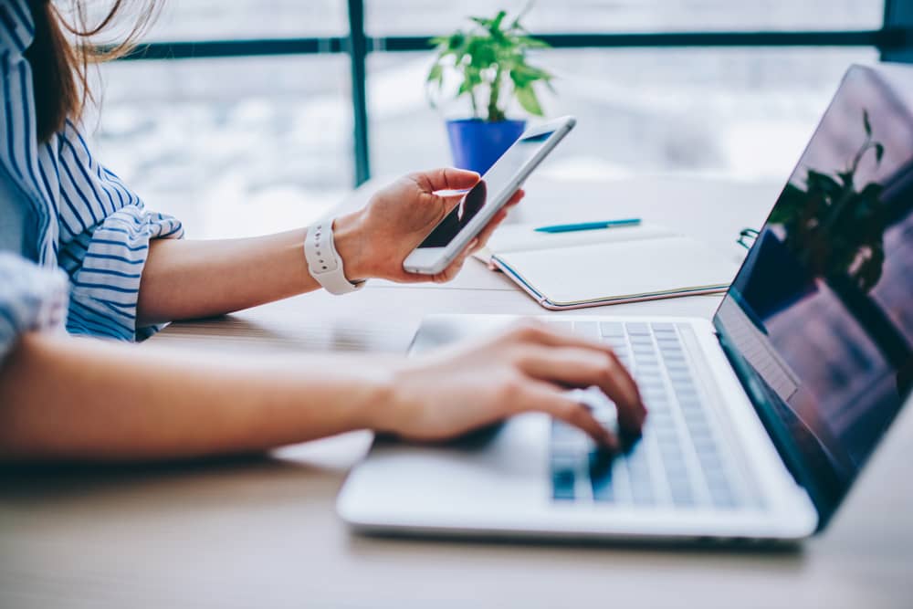 femme étudiant des devis de mutuelle sur son ordinateur portable et son smartphone